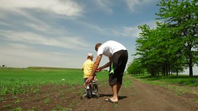 Father helping child learn to ride a bike