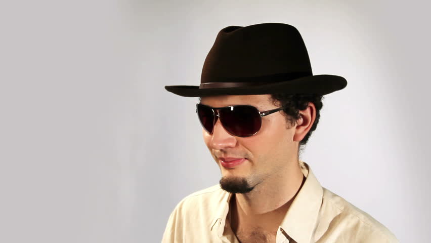 A young man in a hat and glasses flirts