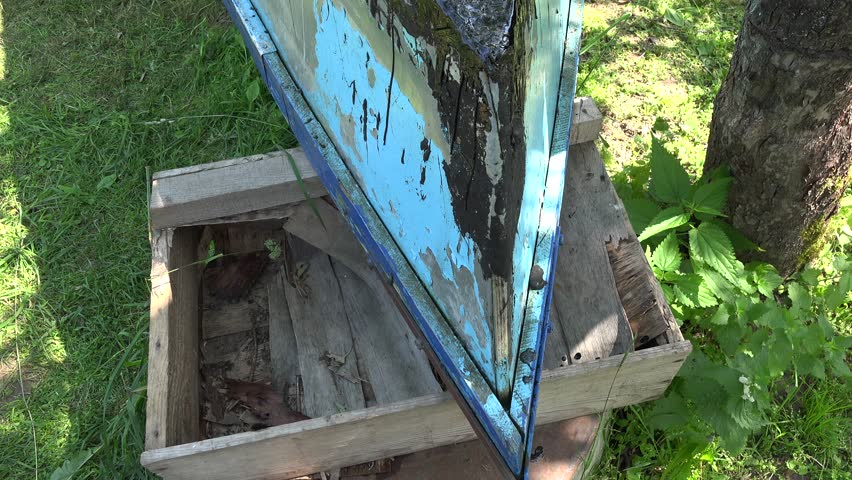 Blue wooden boat and young man lay hot tar with gas burner prime tool. 4K