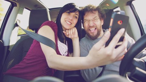 Happy people taking selfie while driving car