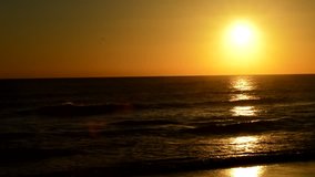 Sunset in the Beach with Yellow Sun on the Ocean Waves