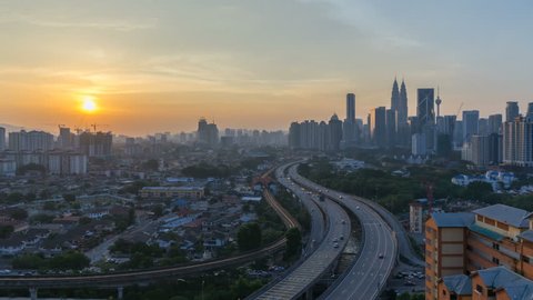 Kuala Lumpur Central Business District skyline sunrise night to day time lapse. tilt down