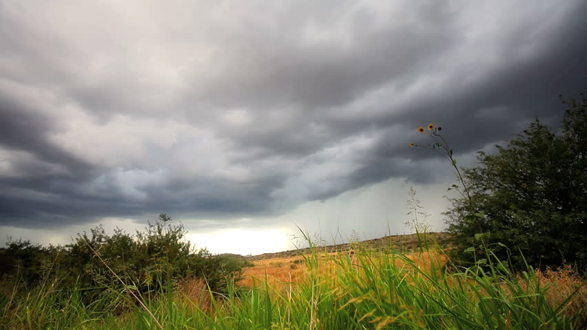 Dark storm clouds forming over open field