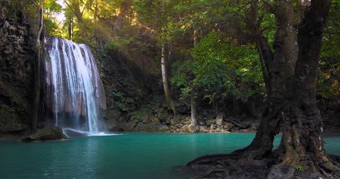 Clear waterfall flowing down turquoise clean river surrounded by jungle trees. Perfect place for relaxation in wild nature. Rainforest full of green plants. Summer time in remote forest
