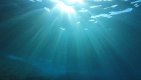 Underwater footage of blue ocean water with sunlight shining below the surface