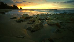 Ocean beach waves on beach and stone during beautiful sunset at Jerudong beach,Brunei Darussalam.It'is a popular getaway spot for outdoor picnics and family outings during the weekend.