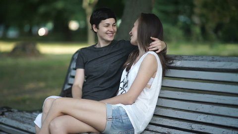 Beautiful lesbians kisses and hugs on bench