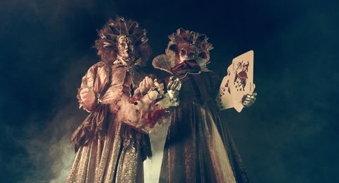 Actors Venetian carnival costumes on stilts with playing cards.