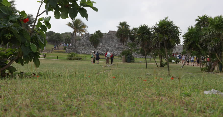 TULUM, MEXICO - DEC 2016: Tulum Mexico tourists at Temple. Mayan ancient walled city along coast. Popular site for tourists historic. Economic stimulus to local economy. Shore of Yucatan Peninsula.