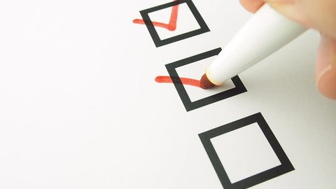 Male hand putting mark on checkboxes of checklist 