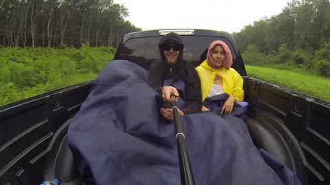 Young couple hitchhiking around the world and goes to the back of a truck in Thailand. GoPro funny selfie HD shot