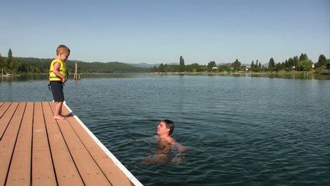 Boy jumps of the dock into his dad's waiting arms.  HD 1080i