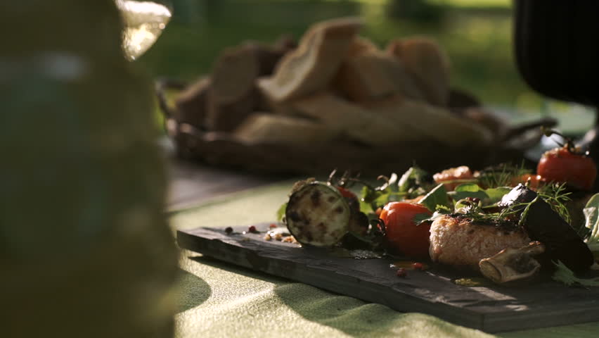 Catering. exquisitely decorated table with delicious meat, salads and wine for Romantic dinner in the forest. outdoor. sunny. picnic. slide. Royalty-Free Stock Footage #22688899