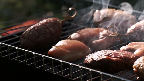 Grill, Frying Fresh Meat, Chicken Barbecue, Sausage, Kebab, Hamburger, vegetables, BBQ, Barbecue, seafood. grilled peppers and onion. Chef turns the meat on the grill Closeup sunny outdoor