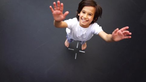 Child jumping on trampoline, high angle