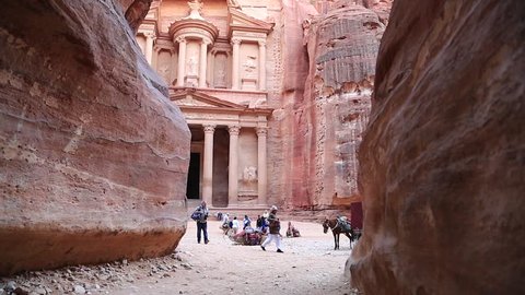 JORDAN, PETRA, DECEMBER 5, 2016: People, horses and camel near Al Khazneh or Treasury at Petra, originally known to Nabataeans as Raqmu, historical and archaeological city, Hashemite Kingdom of Jordan