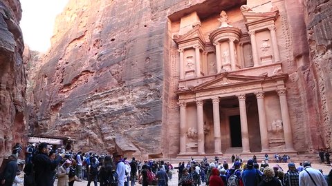 JORDAN, PETRA, DECEMBER 5, 2016: People near Al Khazneh or the Treasury at ancient Petra, originally known to Nabataeans as Raqmu - historical and archaeological city in Hashemite Kingdom of Jordan