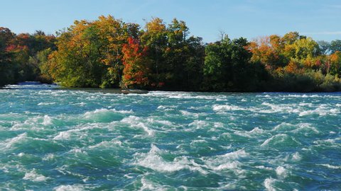 Stormy Niagara River flows to the waterfall. Water foam on the rapids. Slow motion video