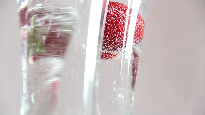 Sparkling water in a glass with a strawberry rotation