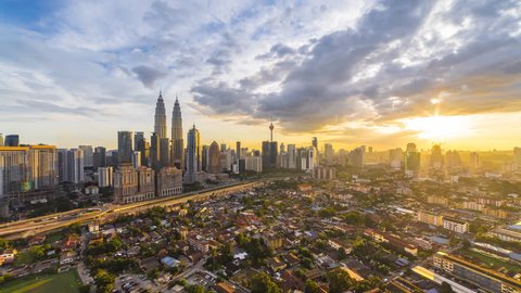 Dramatic and Beautiful Kuala Lumpur city skyline aerial view overlooking busy city streets with busy light trails and national landmarks during dusk. Kuala Lumpur, Malaysia. 4K UHD