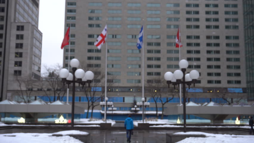Symmetrical Shot of An Urban Plaza Downtown Montreal (Flags of Quebec & Canada)