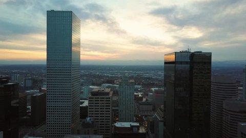 4k Aerial/drone footage of the skyscrapers of Denver, Colorado at sunset.  Rocky Mountains can be seen on the horizon
