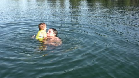 Boy and his dad playing in the water.  HD 1080i