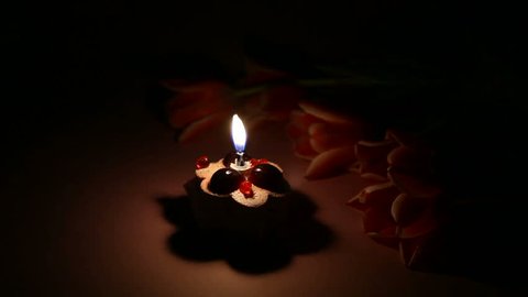candle in the dark with Tulips and sweet cake