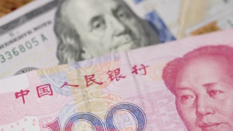 Slider dolly shot moving from US currency - $100 Franklin bill - to Chinese 100 yuan currency. Renminbi money and economy theme. Plays well in reverse too. Shot in 4K UHD.