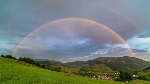 Double Rainbow over Green Meadow and Rural Landscape with Cloudy Sky Time Lapse