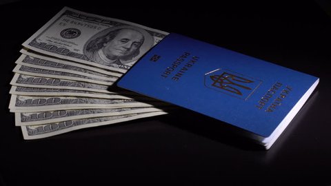 Denominations dollars in the passport are rotated on the black desk