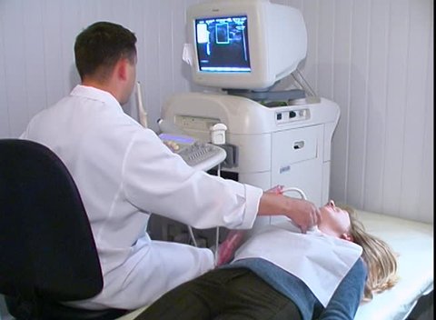 KIEV, UKRAINE, September, 2016: Male nurse performing ultrasound procedure in hospital room. Medical ultrasound examination of the neck.   