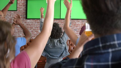 Friends Watching Game In Sports Bar Shot In Slow Motion
