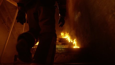 Brave Fireman Runs Up the Burning Stairs. Fire is Everywhere. In Slow Motion. Shot on RED Cinema Camera in 4K (UHD).