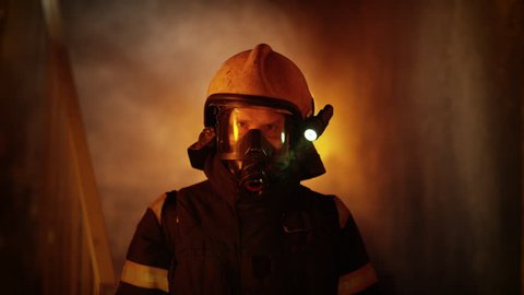 Portrait of a Brave Firefighter Standing in a Burning Building. Raging Fire in the Background. Shot on RED Cinema Camera in 4K (UHD).