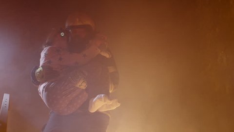 Brave Fireman Descends Stairs of a Burning Building with a Saved Girl in His Arms. Shot on RED Cinema Camera in 4K (UHD).