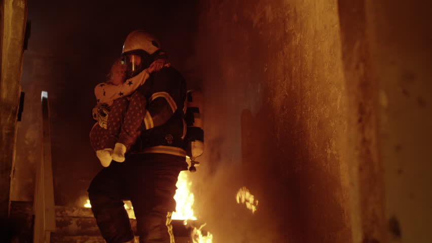 Burning Building. Group Of Firemen Descend on Burning Stairs. One Fireman Holds Saved Girl in His Arms. Shot on RED Cinema Camera in 4K (UHD). Royalty-Free Stock Footage #22782595
