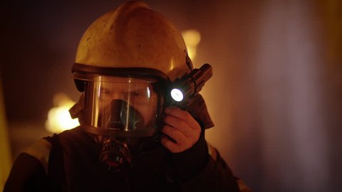 Building is on Fire. Brave Fully Equipped Firefighters Takes off His Helmet. Open Flames in the Background. Slow Motion. Shot on RED EPIC 4K (UHD).