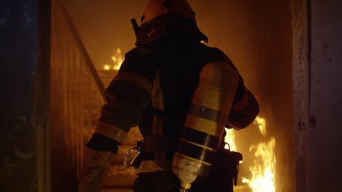 Brave Firefighter Runs Up The Stairs. In Slow Motion. Raging Fire is Seen Everywhere.  Shot on RED EPIC 4K (UHD).