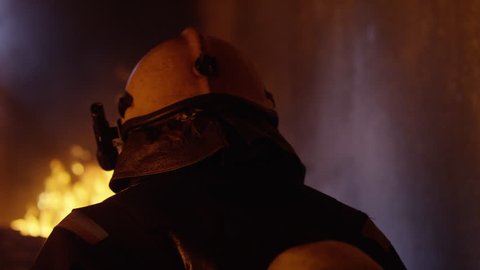 Building is on Fire. Brave Fireman Turns Around and Looks Into the Camera. Tongues of Flame are Licking Walls of the House. Shot on RED EPIC 4K (UHD).