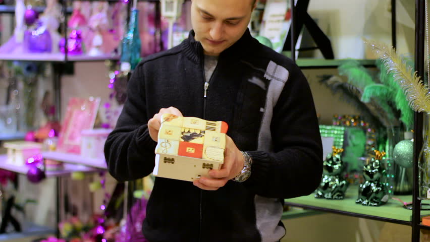 Young Man chooses goods at the gift store