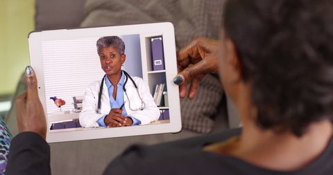 An older black woman talking to her African American doctor via video chat. An elderly black woman talking to her medical professional on her tablet. 4k