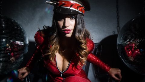 sexy cool latina woman posing in amazing red catsuit and spiked military hat
