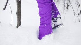 Girl walking in snowboard shoes on the snow