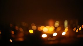 An abstract, bokeh-style video of city lights with a distant fireworks. Turning, dynamic light shapes.