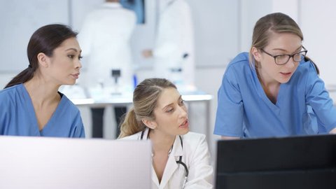 4K Female medical team in modern hospital looking at computer & having a meeting Dec 2016-UK Video Stok