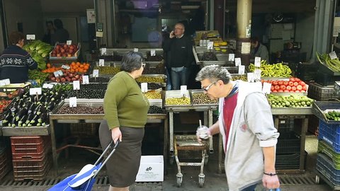 ATHENS, GREECE - CIRCA 2016: Customers buy choosing fresh vegetables, olives, tomatoes and organic vegetables and fruits at the Athens Central Market - best food in town most traditional Greek cuisine