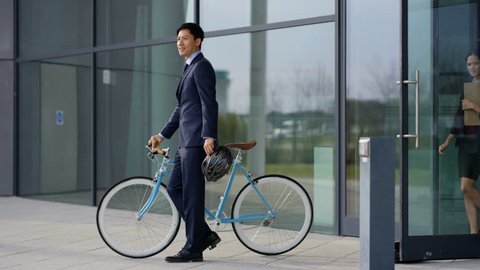 4K Businessman with bicycle leaving office at end of day & coworkers following Dec 2016-UK
