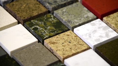 Floor tiles concept. Kitchen granite counter top color samples. Flooring tiles in different colors. Slow motion of granite, marble and quartz stone squares. Rock tiles rotating. 