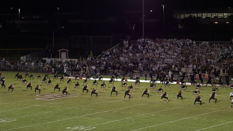Circa September 2016, Lone Peak Utah: Aerial pan of high school cheerleaders and band performing at football game